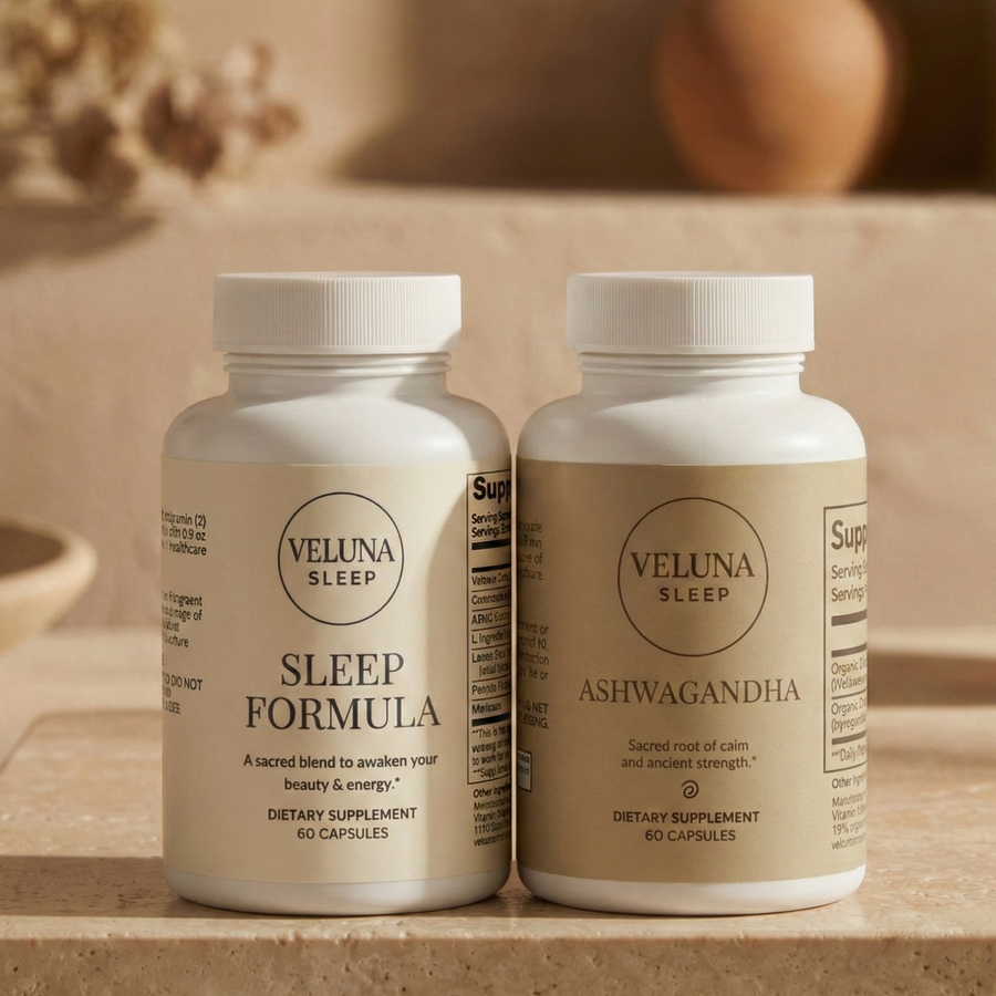 Veluna Sacred Soothe Booster Bundle, Sleep Formula and Ashwagandha bottles on a travertine slab in warm light