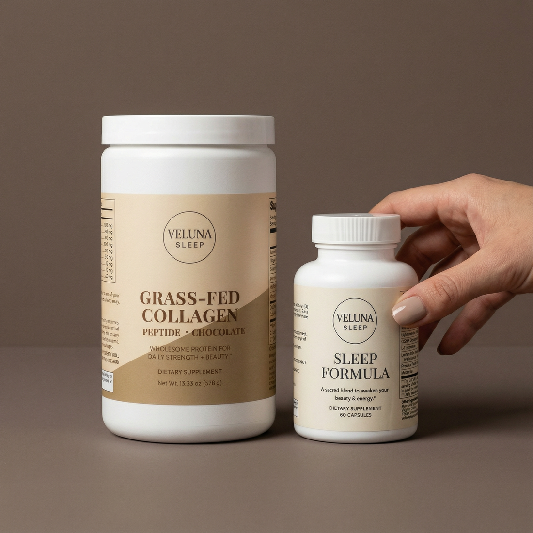 Veluna Deep Restore Booster Bundle on taupe, a hand reaching for the Sleep Formula bottle beside the collagen tub
